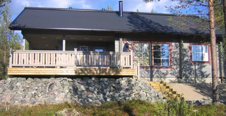 harmaa puinen kesämökki, joka käyttää Nilan poistoilmalämpöpumppua